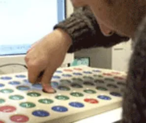 Una persona preme con il dito indice uno dei grandi tasti circolari della tastiera espansa
